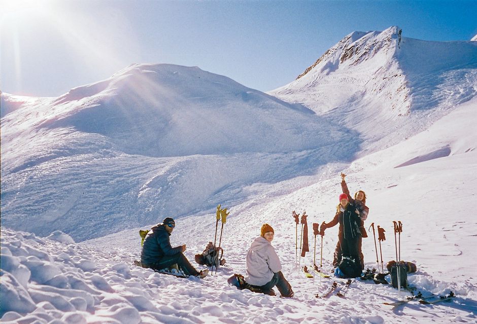 Group of skiers taking a break on the snowy slopes of Mont Blanc under a bright winter sun.