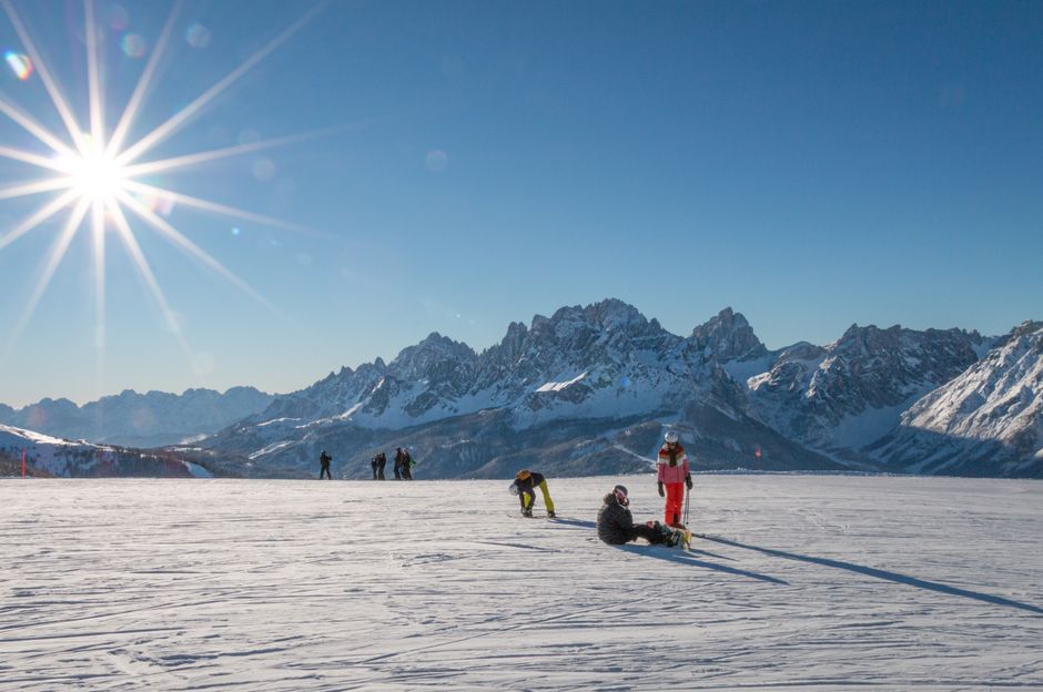 Skiers enjoy a sunny winter day in Versciaco with stunning mountain views.